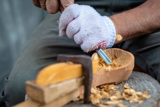 Craftsman demonstrates the process of making wooden spoons handmade using tools. National crafts concept.