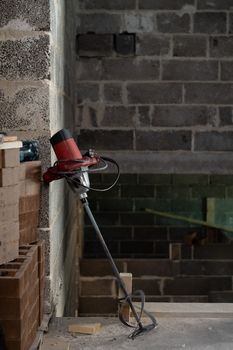 Electric drill with a mixer in a newly constructed building.