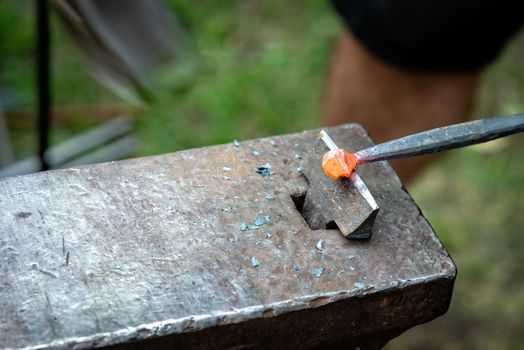 the blacksmith forged a strip of hot metal. close up - Image