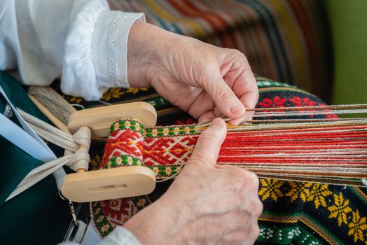 Woman working at the weaving loom. Traditional Ethnic craft of Baltic. - Image