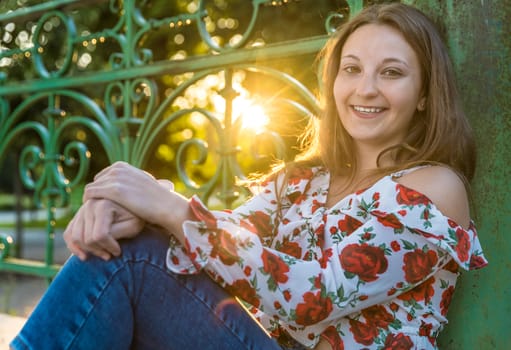 Portrait of a young woman in the park at sunset.