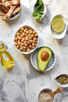 Avocado Hummus, recipe ingredients. Dish based on chickpeas and avocado. On white marble background