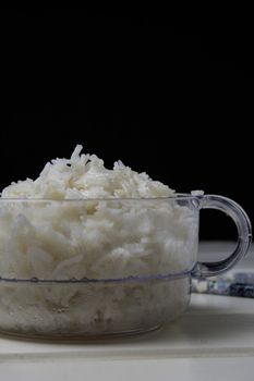 Bowl of white rice, clear container and black chalkboard background 