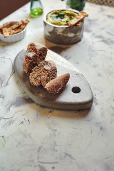Rye bread, cut into slices, on stone table on the table set