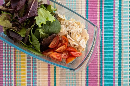 fresh vegetable salad with tuna, on multicolored tablecloth