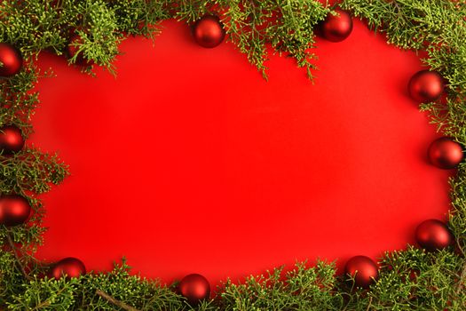 Flat lay red Christmas copy space with pine branches and red Christmas baubles all around