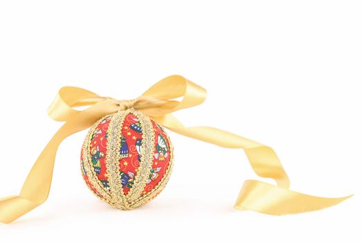 Isolated handmade decoupage Christmas bauble with gold satin flake ribbon on white background