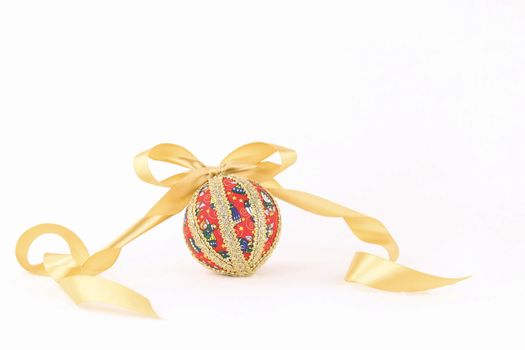 Isolated handmade decoupage Christmas bauble with gold satin flake ribbon on white background