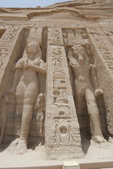 Colossal statues of Ramses II and Queen Nefertari at the entrance to Abu Simbel Temple in Egypt