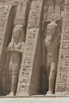 Colossal statues of Ramses II and Queen Nefertari at the entrance to Abu Simbel Temple in Egypt