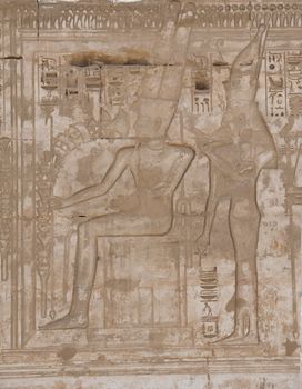 Egyptian hieroglyphic carvings on a wall at the Temple of Medinat Habu