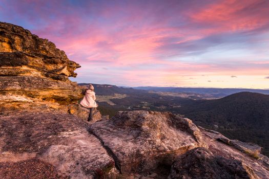 Woman watching magnificent winter sunset in the mountains of Australia