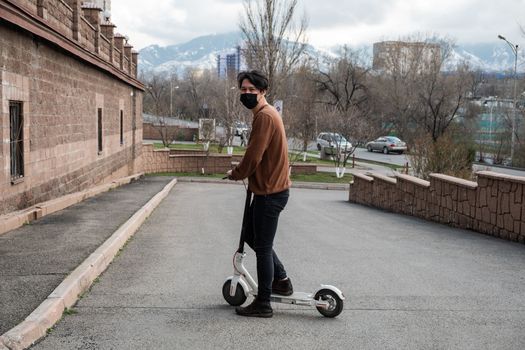 Young man riding a scooter in the city