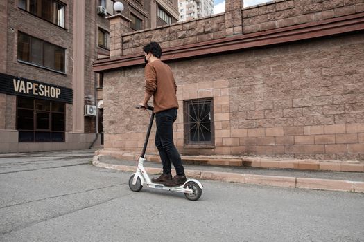 Young man riding a scooter in the city