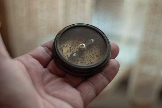 Close-Up Of Hand Holding Navigational Compass