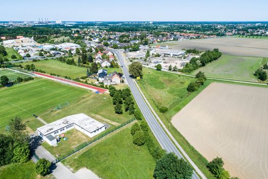 Aerial view of the clubhouse of a regional football club on the outskirts of the city next to a big street, football field in the background, near Wolfsburg