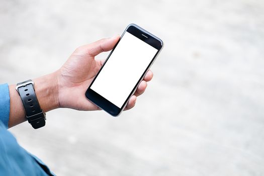 Cropped shot view of man hands holding smart phone with blank copy space screen for your text message or information content, female reading text message on cell telephone during in urban setting. 