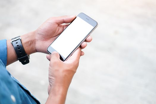 Cropped shot view of man hands holding smart phone with blank copy space screen for your text message or information content, female reading text message on cell telephone during in urban setting. 