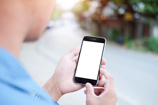 Cropped shot view of man hands holding smart phone with blank copy space screen for your text message or information content, female reading text message on cell telephone during in urban setting. 