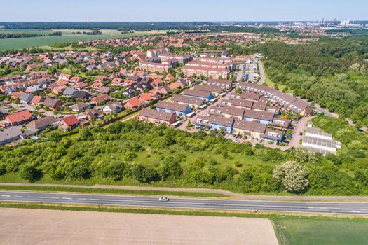 Aerial view of a suburb on the outskirts of Wolfsburg in Germany, with terraced houses, semi-detached houses and detached houses, arable land in the foreground, made with drone