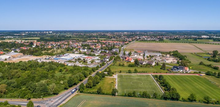 Aerial view of an industrial estate on the outskirts of Wolfsburg, Germany, with a football pitch in the foreground, made with drone