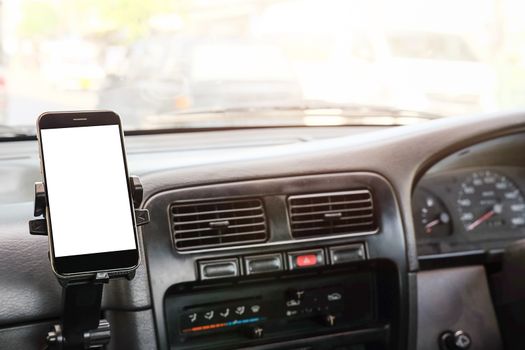 Cropped shot view The driver uses the phone while driving. Modern smart phone with round edges. Isolated screen for mockup. Car navigation display in background. 