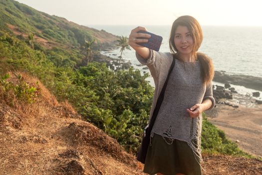 Young woman traveling around Goan coastline beach in India county.