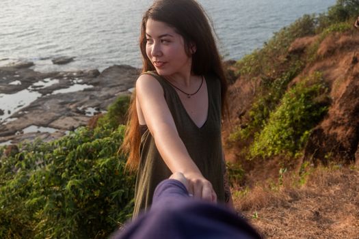 Shot of a young woman leading someone by the hand at the beach