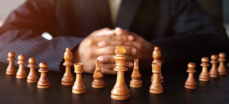 Businessman moving chess figure in competition success management or leadership concept 