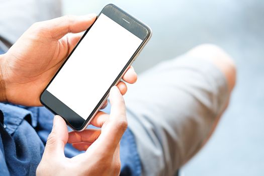 Cropped shot view of man hands holding smart phone with blank copy space screen for your text message or information content, female reading text message on cell telephone during in urban setting. 