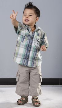 Portrait studio photo shoot of young mixed race asian child isolated on a blue background