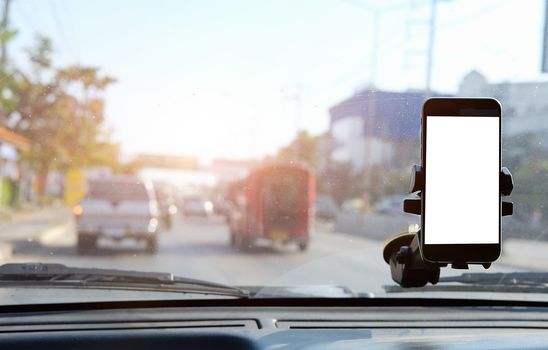 Cropped shot view The driver uses the phone while driving. Modern smart phone with round edges. Isolated screen for mockup. Car navigation display in background. 