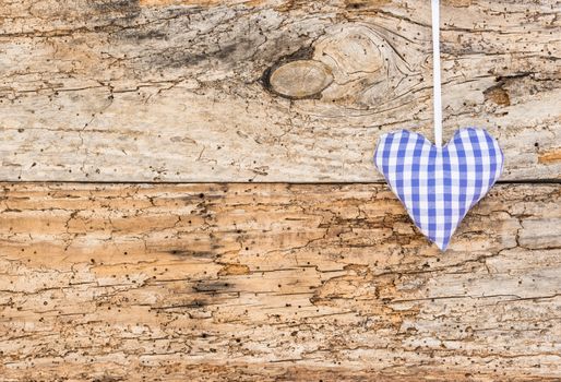 Rustic blue heart hanging on old wood with copy space
