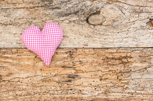 Romantic pink heart on rustic old wood background for Valentine card with copy space