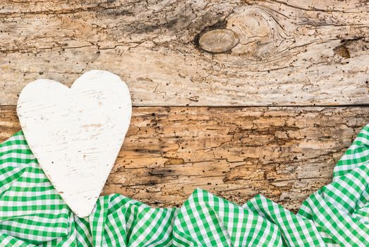 Rustic background for mothers day with white heart and green fabric