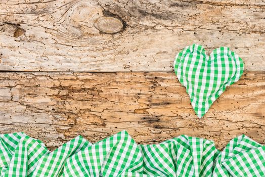 Rustic background with green heart on vintage wood with copy space