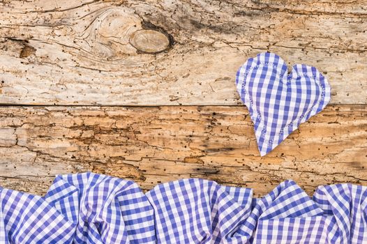 Rustic blue fabric heart on old wood background with copy space