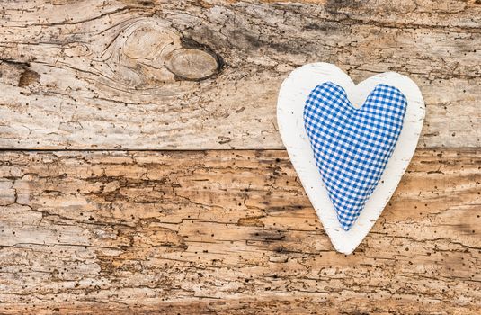 Blue rustic fabric heart on vintage wooden background with copy space