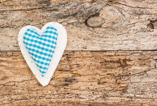Blue fabric heart on rustic wooden background with copy space