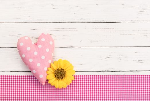 Cute pink heart and blossom on white wooden background