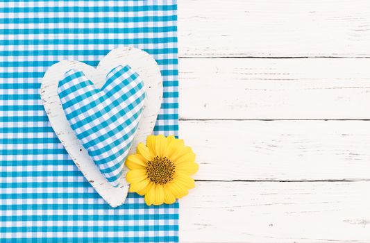 Cute blue heart and blossom on white wooden background with copy space

