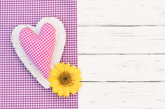 Romantic pink heart with yellow flower on white wooden background with copy space