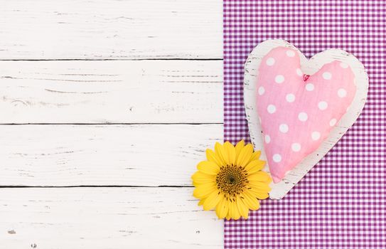 Baby girl birthday greeting card background with pink heart and yellow flower