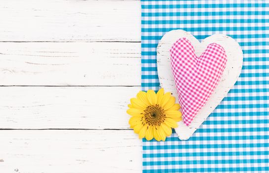 Romantic pink heart with yellow blossom on white wooden background with copy space