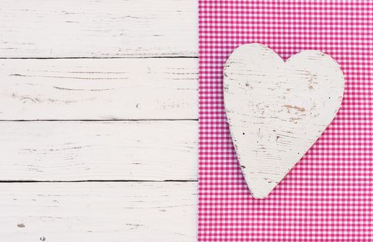 White heart on pink fabric background with copy space

