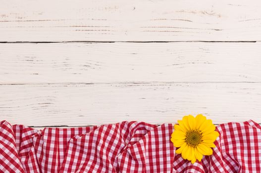 White wood table with red fabric and flower with copy space