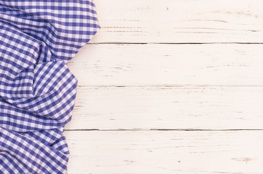 Rustic white wooden table surface with blue checkered cloth, top view