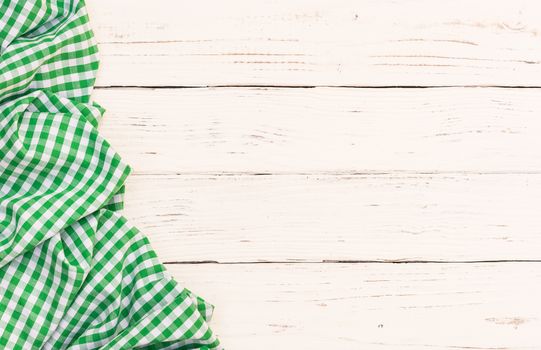 White wooden table background with rustic green checkered tablecloth, high angel view

