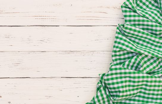 Rustic white wooden table surface with green checkered cloth, top view