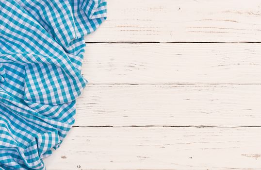 Rustic white wooden table surface with blue checkered cloth, top view